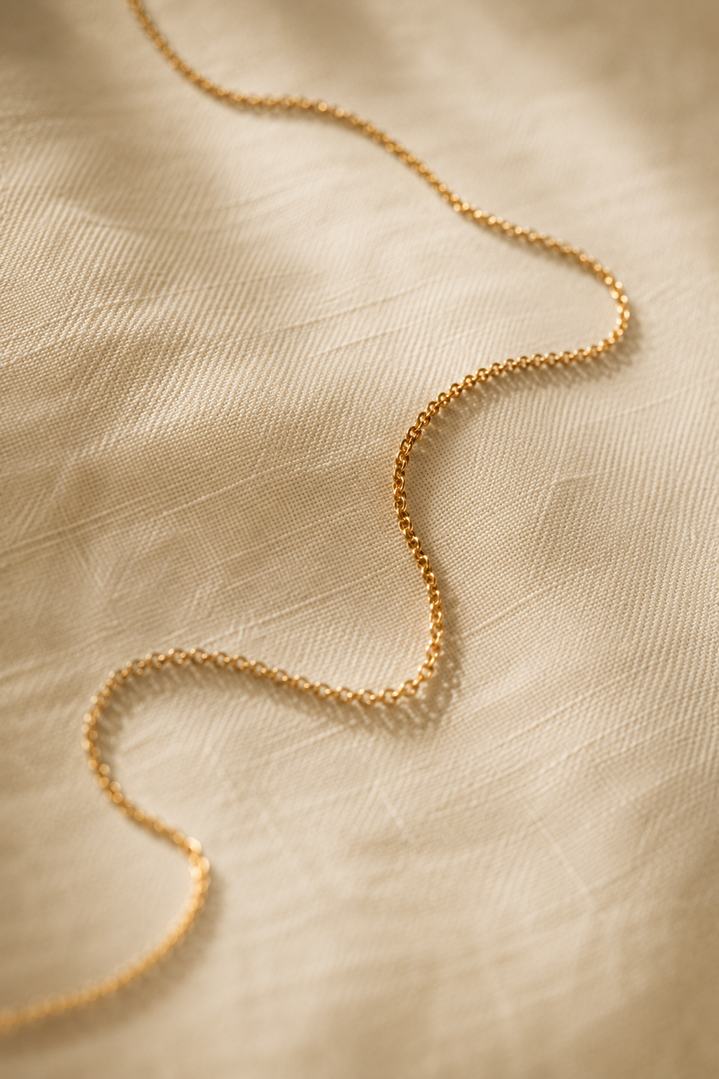 Gold chain resting on natural linen